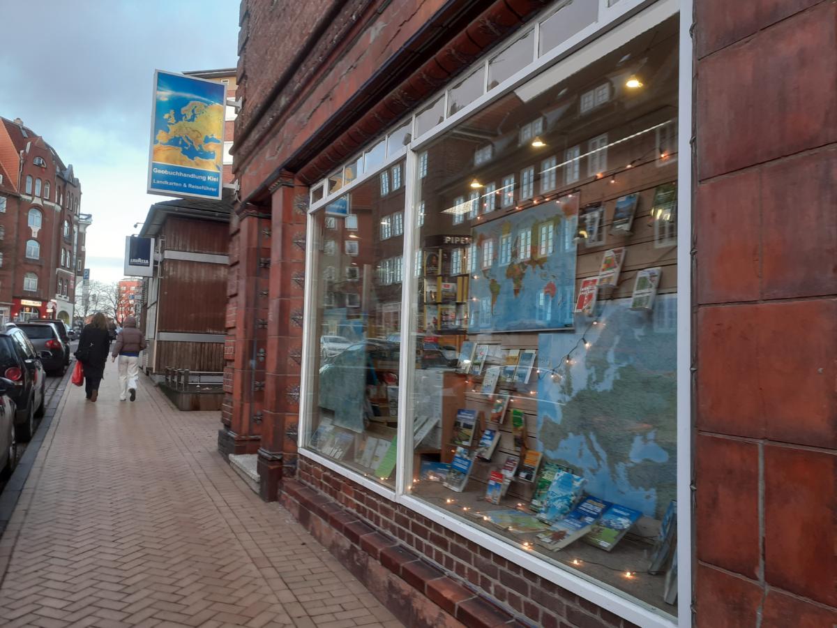 das Ladengeschäft der Geobuchhandlung Kiel im Schülperbaum 9 - Blick auf die Fassade, auf Außenwerbung und Schaufenster